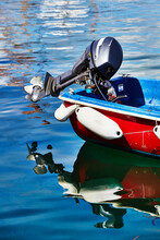 Isles Of Scilly, United Kingdom - Detail Of An Outboard Motor On A Small Boat Floating In Calm Water In The Port Of Hugh Town, St.Mary´s. Reflection In Water.