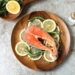 raw salmon steak with lemon and rosemary on a light table