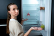 © Grustock - Young woman in the kitchen looks inside an empty refrigerator without food.