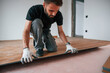 © standret - Hand work. Man is installing new laminated wooden floor