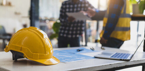 Engineers, architects and contractors discussing on the background of a real estate construction project concept image.