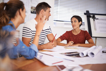 Poster - Listening intently to his opinion. a group of young designers working together in an office.