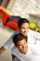 Wall Mural - Believing that they can fly high together. a young man giving his girlfriend a piggyback.