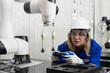 © amorn - Automated manufacturing industries. Female engineer control autonomous robotics arm for manufacturing lines in workshop. Innovative self-learning technology concept