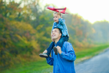 A Happy parent walks along the road with a child and an airplane in the park on nature travel