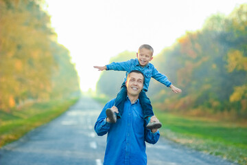 Wall Mural - A Happy parent with child are walking along the road in the park on nature travel