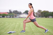 © AW/peopleimages.com - Ready to feel the burn. a young woman stretching on a grassy field.