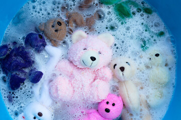 Soak toy teddy bears in laundry detergent water dissolution before washing.  Laundry concept, Top view