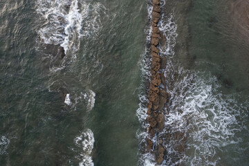 Poster - Waves hit rock stone above top view