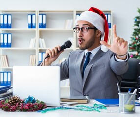 Wall Mural - Young businessman celebrating christmas in the office