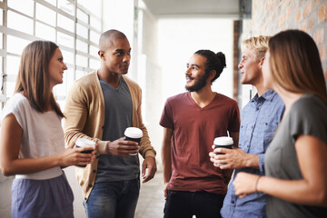 Wall Mural - Grabbing some coffee with a few colleagues. a diverse group of friends in a hallway.