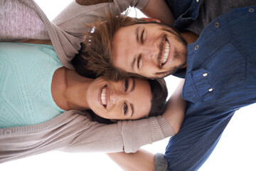 Canvas Print - Holding onto love. a happy young couple standing close together - directly below.