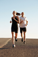 Poster - Going the distance together. a young couple exercising outdoors.