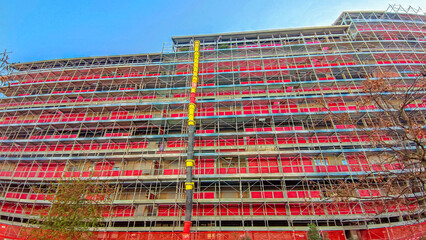 Scaffolding temporary structure for building structure support in construction. Front view of a scaffold installation for house renovation. working platform for workers at work.