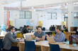 © Yuri Arcurs/peopleimages.com - The ideas team in action. colleagues talking together while working on laptops at a desk in a large office.