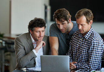 Poster - On last run thru. three male coworkers working on a laptop together.