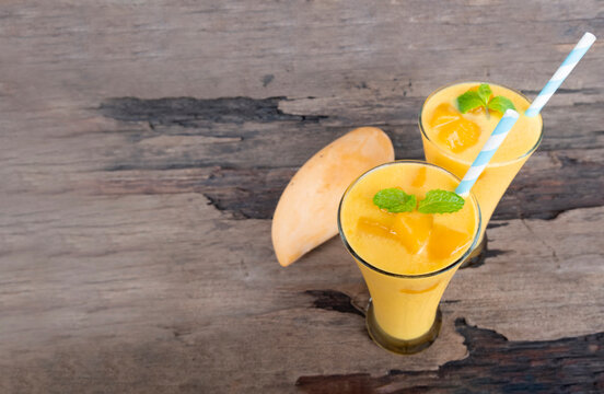Fototapete - Mango smoothies orange colorful fruit juice beverage healthy high protein the taste yummy in glass on wood background from top view.
