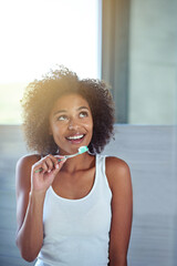 Poster - Getting some ideas while getting ready. a young woman brushing her teeth in the bathroom.