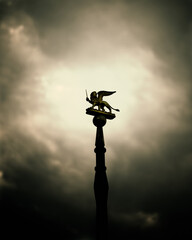 Venetian Lion statue on a dramatic sky as a background.