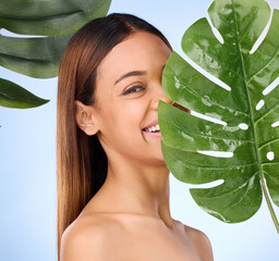 Wall Mural - Woman, portrait and leaf in natural beauty skincare cosmetics or self love and care against blue studio background. Happy female smile for perfect skin, leafy green organic plant or sustainable eco