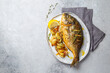 Grilled sea bream or dorada on gray plate. Gray background