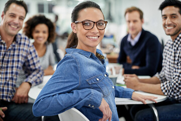 Canvas Print - Feeling good about my office community. Relaxed businesswoman smiling at the camera with her colleagues at a meeting table.