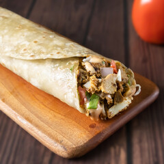 Wall Mural - Tandoori Chicken Wrap paratha roll served in wooden board side view of indian fastfood