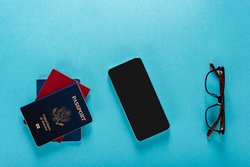 Wall Mural - American passport, glasses and smartphone for booking flight tickets via mobile app