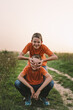 © Анастасія Стягайло - Funny twin brother boys in orange t-shirt playing outdoors on field at sunset. Happy children, lifestyle.