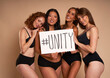 © gpointstudio - Group of women in underwear looking at camera and holding banner