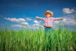 © ValentinValkov - Little farmer boy with straw hat in a green wheat field. Agriculture and farming concept.