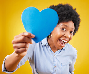 Poster - Paper, heart and excited with black woman in studio for romance, positive and emotion. Happiness, love shape and giving with female isolated on yellow background for date, feelings and affectionate