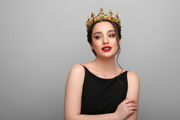 Wall Mural - Beautiful young woman wearing luxurious crown on light grey background, space for text