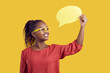 Studio shot of a cheerful black female school teacher in glasses showing a mock up speech bubble card sharing with students interesting information, feedback, idea, thought, or useful English phrase