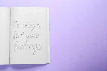 Wall Mural - Notebook with phrase It`s Okay to Feel Your Feelings on violet background, top view. Space for text