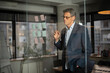 © JustLife - Portrait of successful businessman in office. Man writing ideas on colorful stickers on glass wall