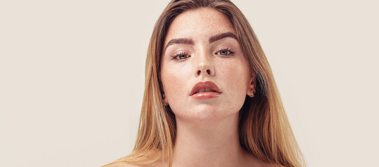 studio beauty portrait of young natural woman with freckles on her face. ideal, delicate makeup with