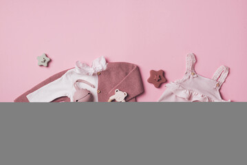 Set of pink clothes and accessories fot newborn girl. Toys, bodysuit, romper, knitted cardigan, shoes, bib on pastel backgroundd. Mock up tor text. Baby shower concept. Flat lay, top view