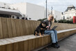© Srdjan - Young university girl sitting outdoor with her adopted dog working on laptop. She left the apartment for her student roommate boyfriend they need privacy because they share a rented apartment or room