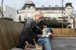 © Srdjan - Young university girl sitting outdoor with her adopted dog working on laptop. She left the apartment for her student roommate boyfriend they need privacy because they share a rented apartment or room