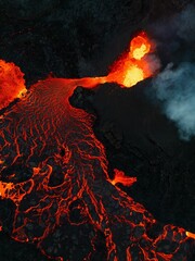 Wall Mural - Vertical shot of lava flowing over rocky surface during 2022 Meradalir volcano eruption, Iceland