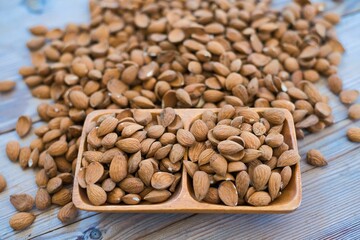 Sticker - Almonds in a wooden bowl on an old wooden table