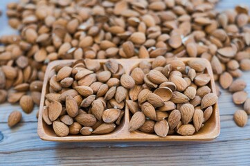 Poster - Almonds in a wooden bowl on an old wooden table