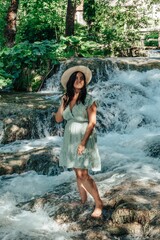 Wall Mural - Portrait of happy young woman in front of stream with cascades