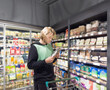 © lado2016 - Man choosing frozen food from a supermarket freezer., reading product information