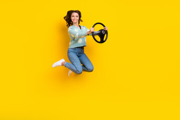 Wall Mural - Full body profile portrait of crazy lady jumping arms hold wheel empty space isolated on yellow color background