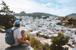 Family father and child traveling in Rhodes island, Greece sightseeing Lindos city white houses aerial view summer vacations lifestyle Europe destinations