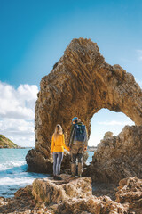Wall Mural - Couple traveling in Greece together outdoor travel lifestyle active summer vacations man and woman enjoying arch in the sea view explore Rhodes island