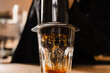 © Rabizo Anatolii - Falling coffee drops in cup close-up. Aeropress coffee. Process of pouring coffee in cup. Barista is pushing aeropress for pouring coffee drops.