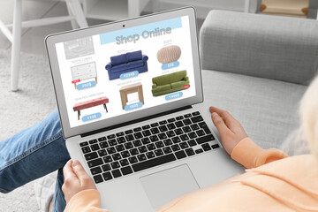 Woman with laptop buying online new furniture at home